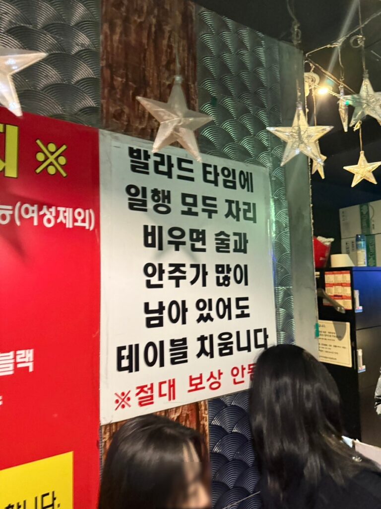 Sign warning that empty tables are cleared during ballad time