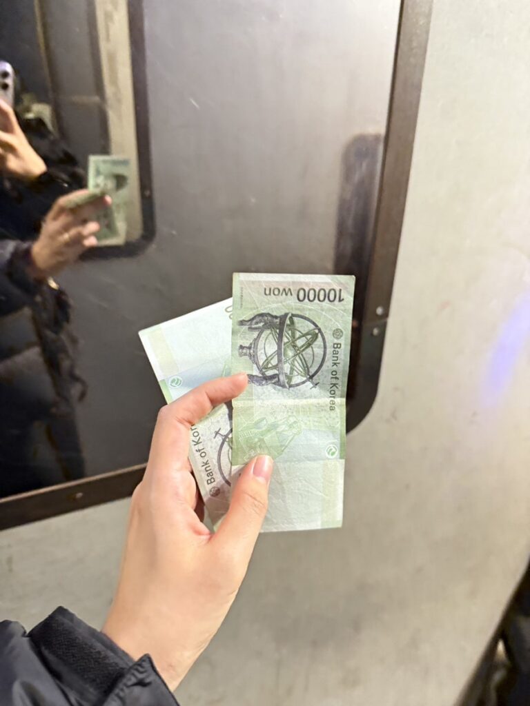 Holding ₩10,000 notes while waiting in line