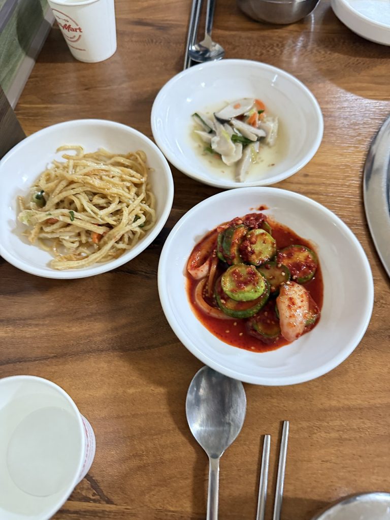 Side dishes of bean sprouts, cucumber and kimchi