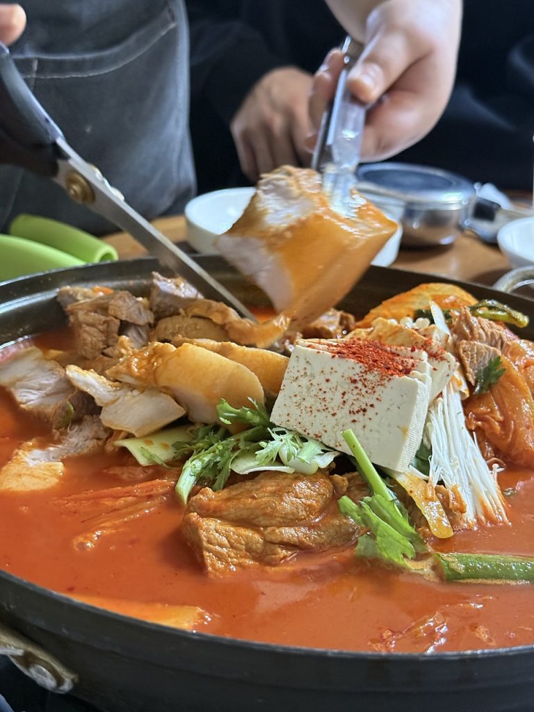 Lifting a thick piece of pork with tongs