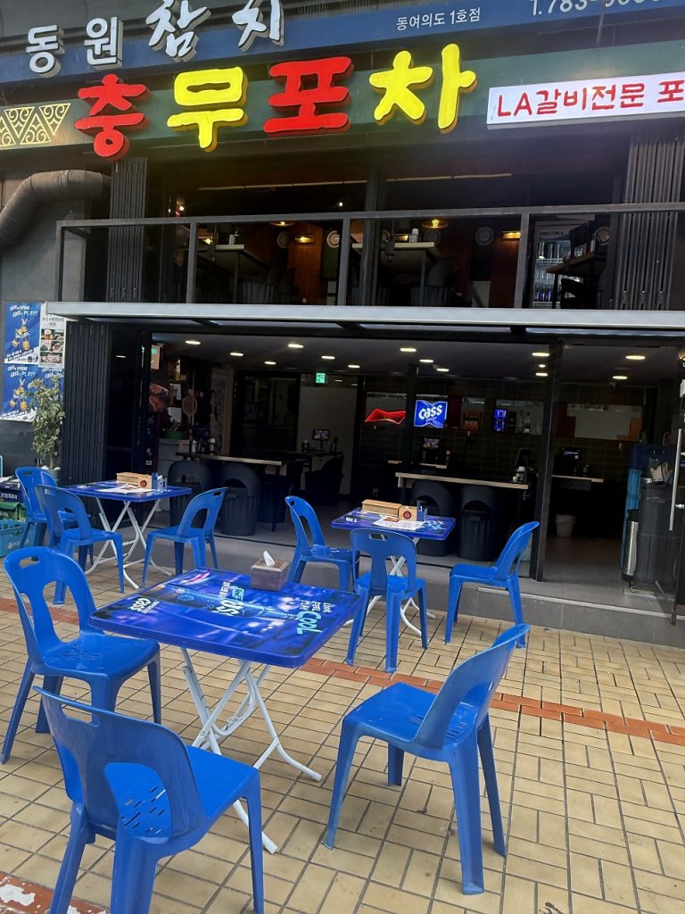 Blue plastic tables set out in front of the pocha