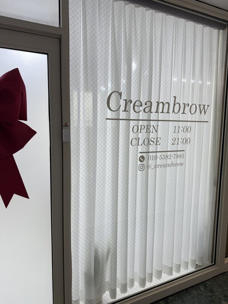 Cream Brow door with opening hours on the frosted glass