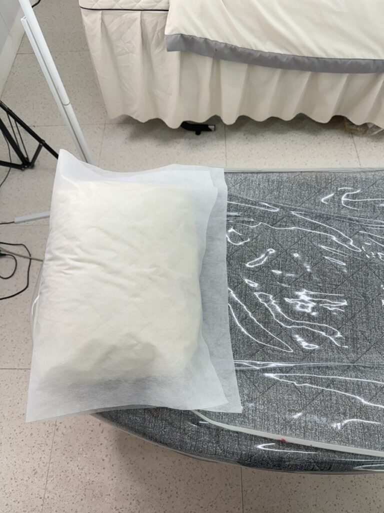 Fresh pillow in a disposable cover on the treatment bed