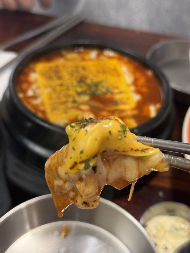 Rice cake wrapped in melted cheese from the stone pot
