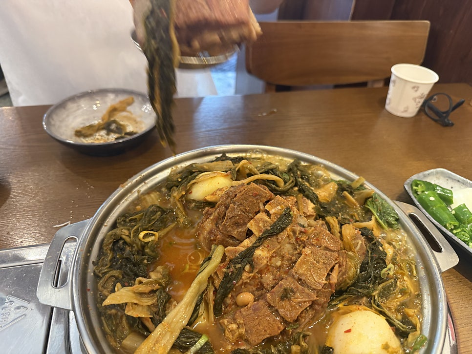 Lifting a big bunch of cabbage greens from the stew
