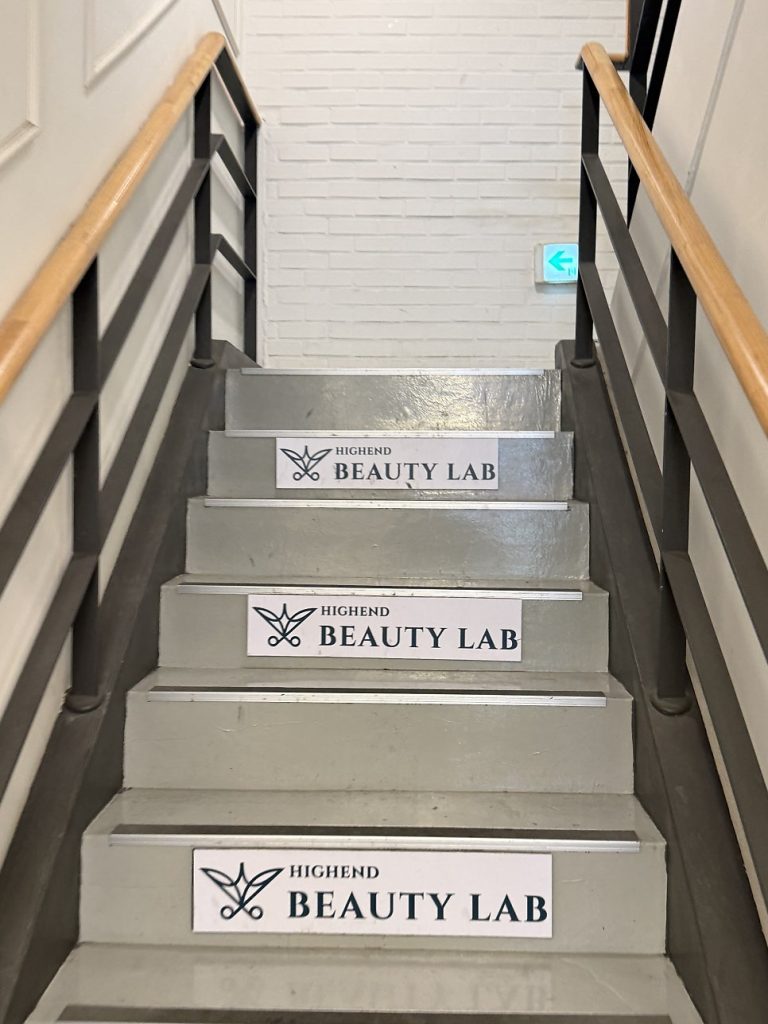 Stairway entrance with the salon logo