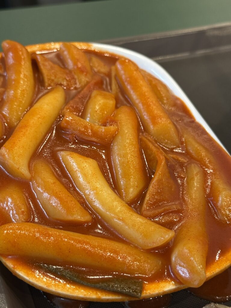 Close-up of chewy rice cakes in red tteokbokki sauce