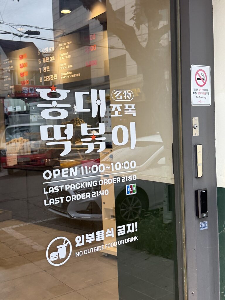 Door showing opening hours, last order time and a no-outside-food sign