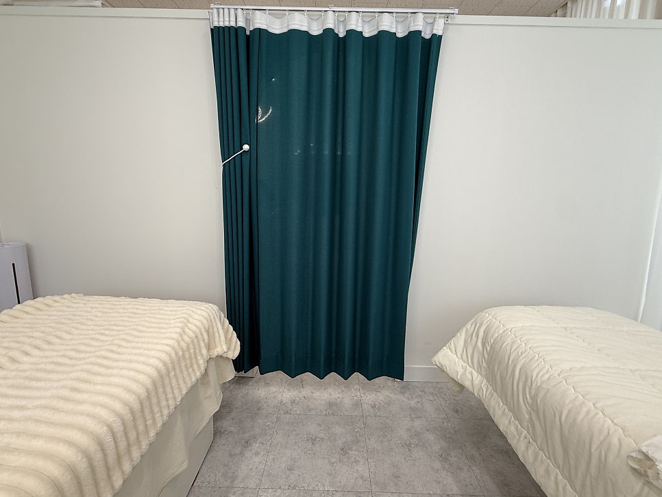 Treatment beds separated by a curtain