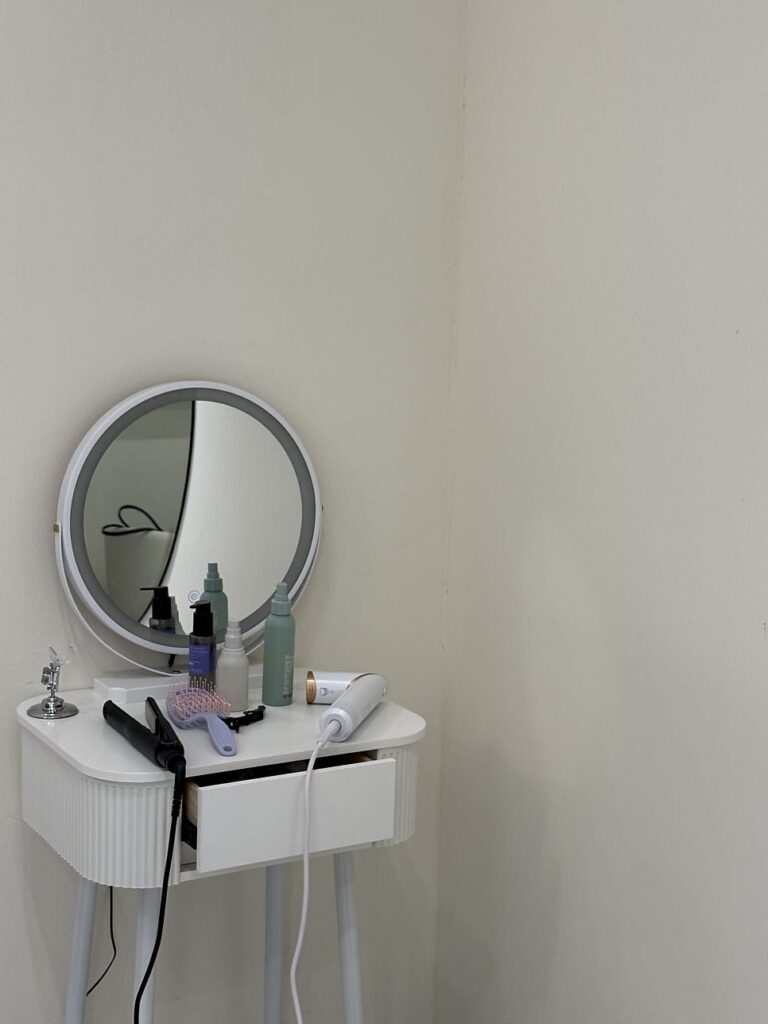 Powder room vanity with mirror and hair tools