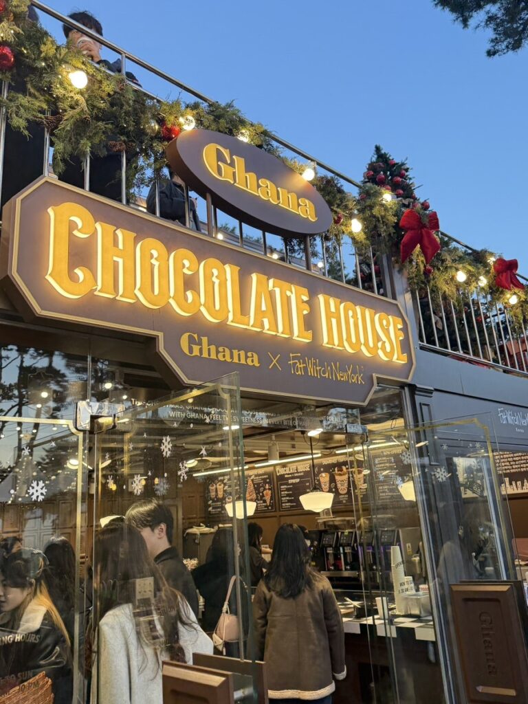 Ghana Chocolate House shop front glowing at dusk