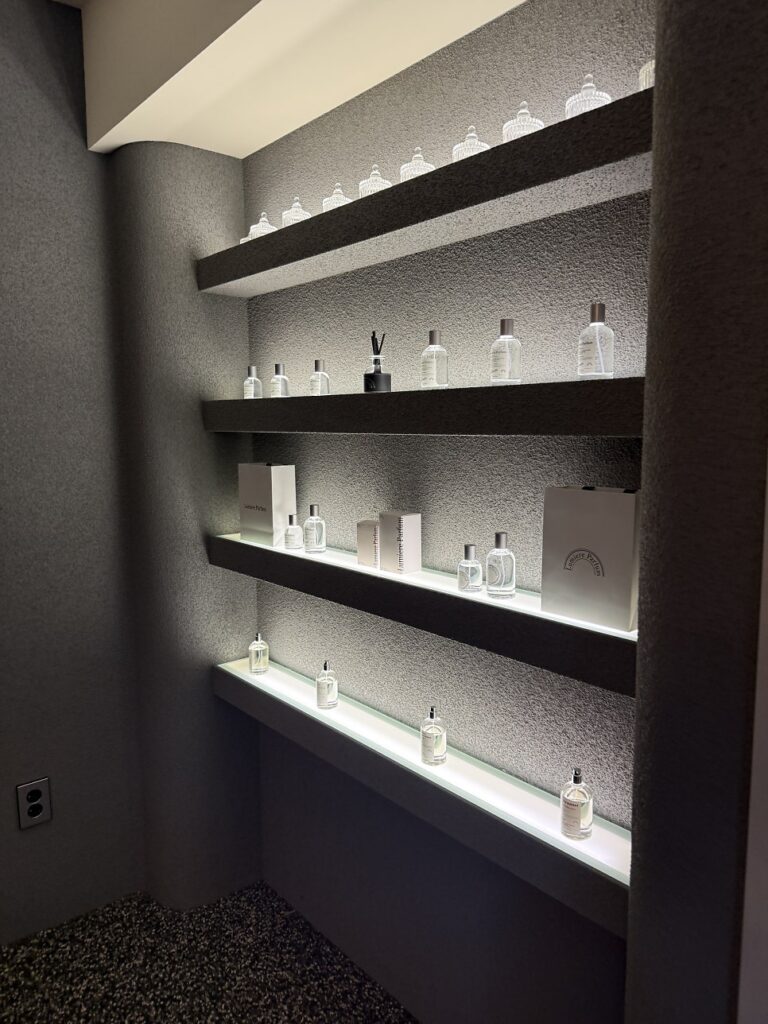 Lit shelves displaying finished perfumes and diffusers