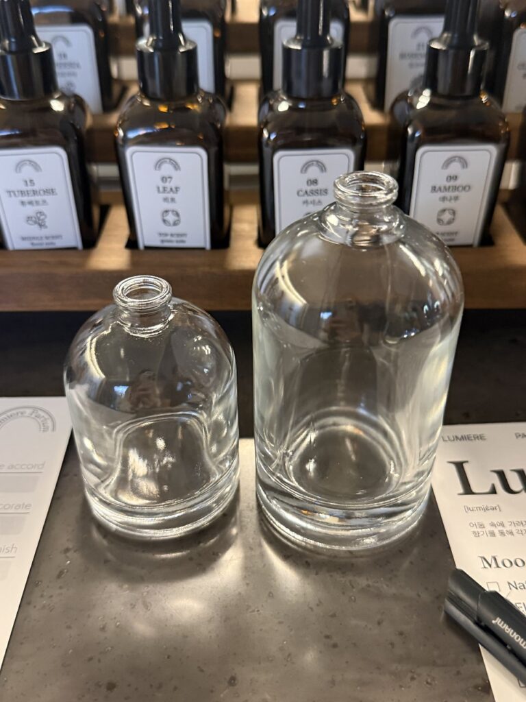 Empty 50 ml and 100 ml perfume bottles side by side