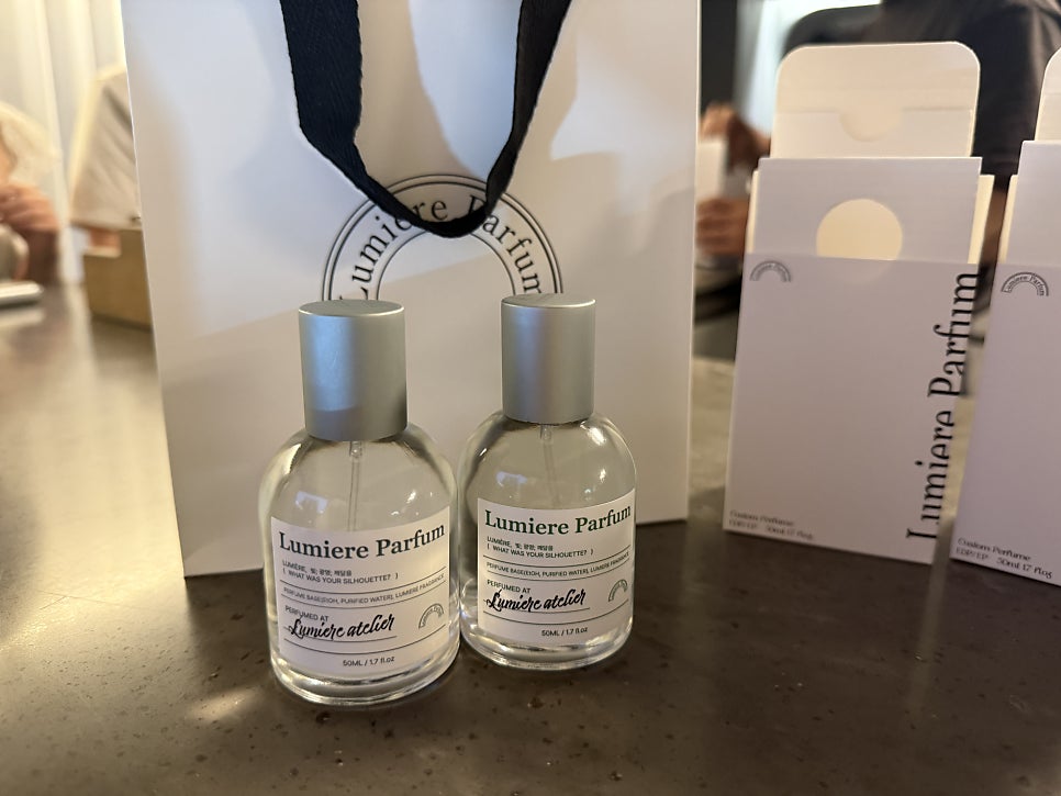 Two finished Lumiere Parfum bottles with box and shopping bag