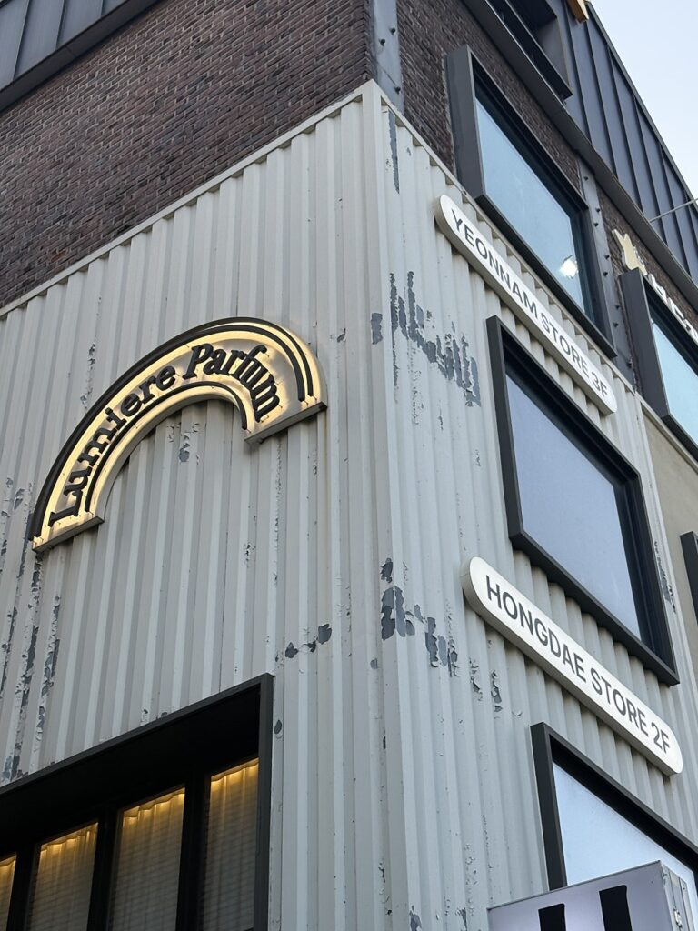 Corner building with the Lumiere Parfum arch logo and floor signs