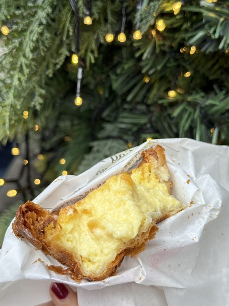 Inside of the egg tart showing soft custard and flaky layers
