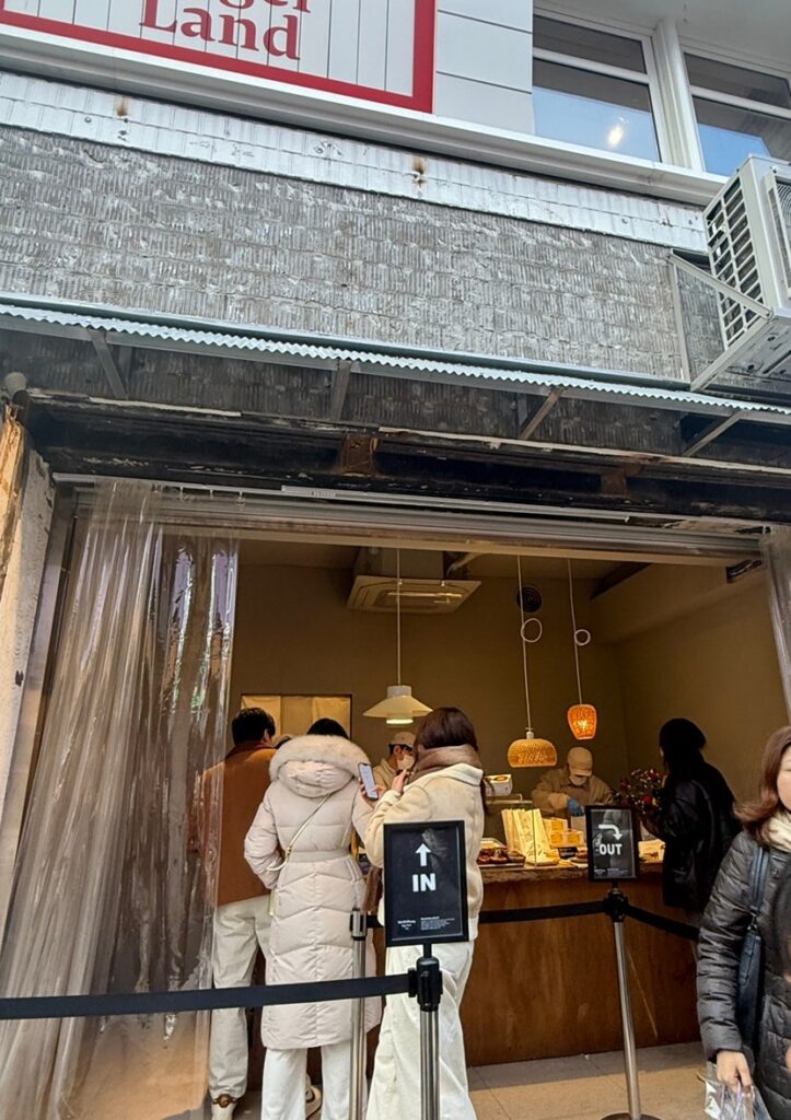 Shop front with customers lined up inside the rope line
