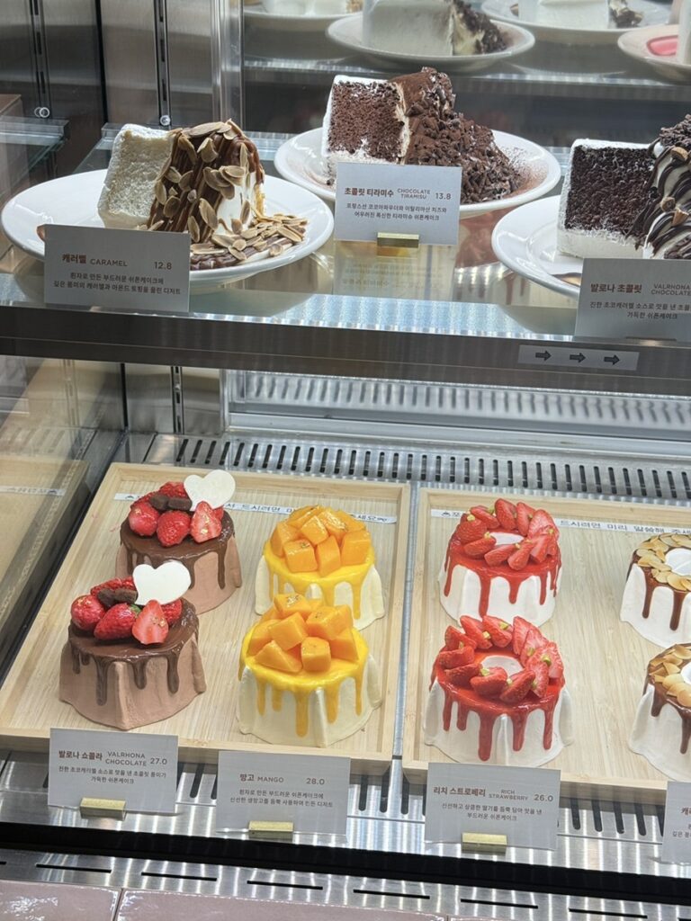 Display case of whole chiffon cakes with strawberry and mango