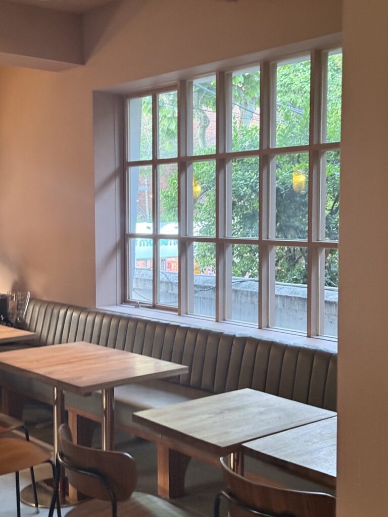 Booth seating along a window filled with greenery