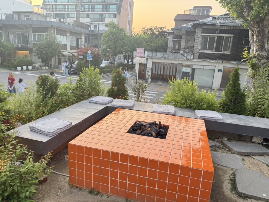 Orange-tiled outdoor fire pit with benches on the terrace