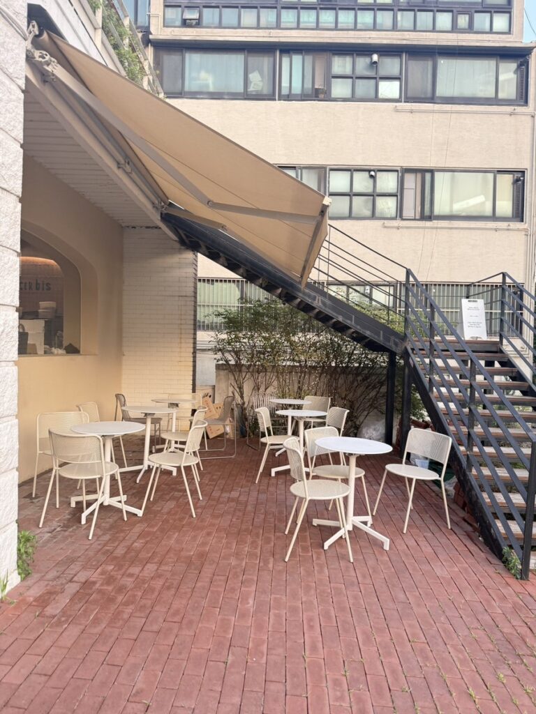 Terrace with white chairs and tables under an awning