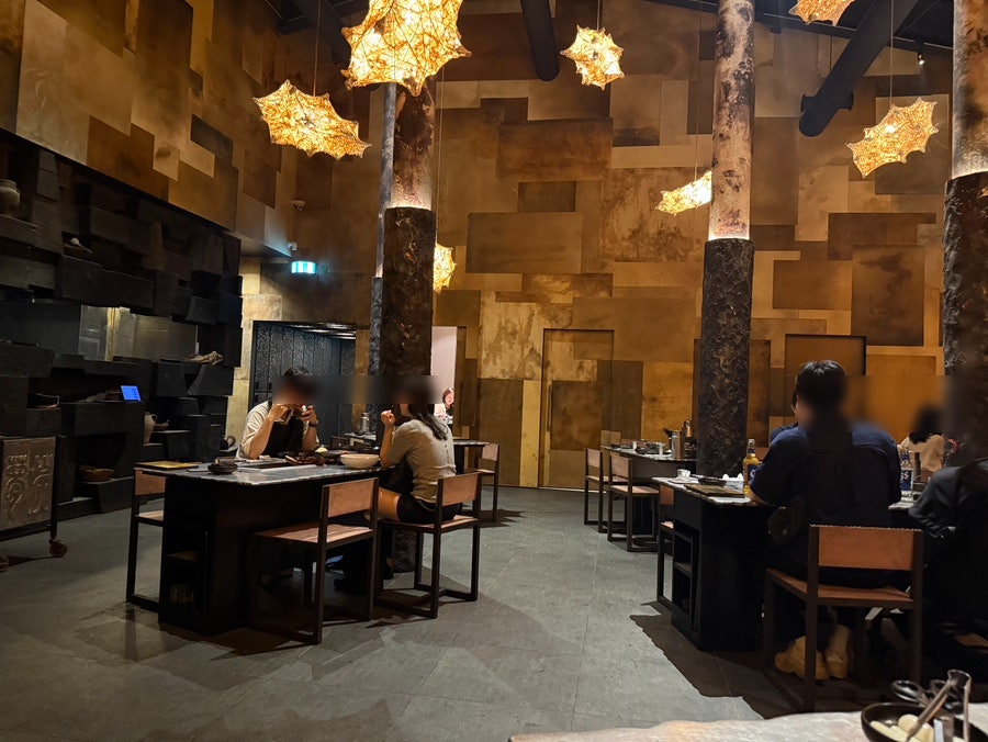 Golden dining room with tree-trunk pillars and lanterns