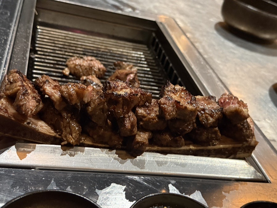 Grilled short rib pieces resting by the grill