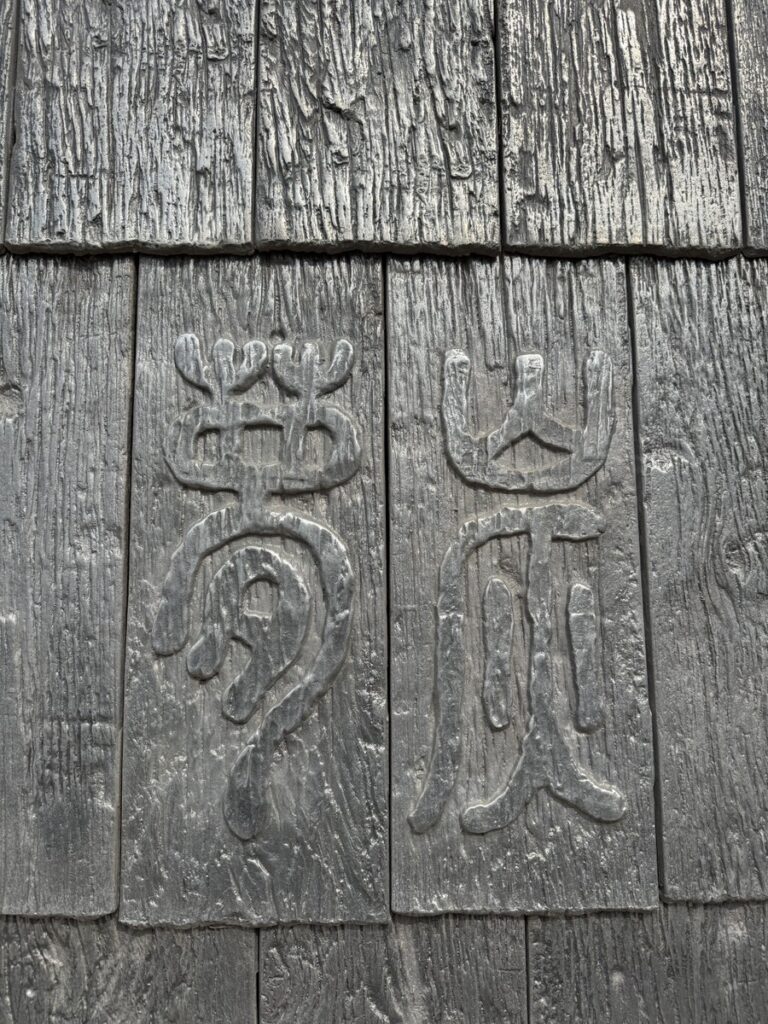 Carved wooden wall with the Mongtan name at the entrance