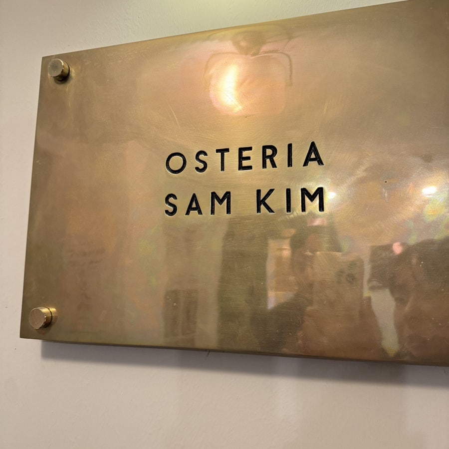 Gold Osteria Sam Kim nameplate on the wall by the entrance
