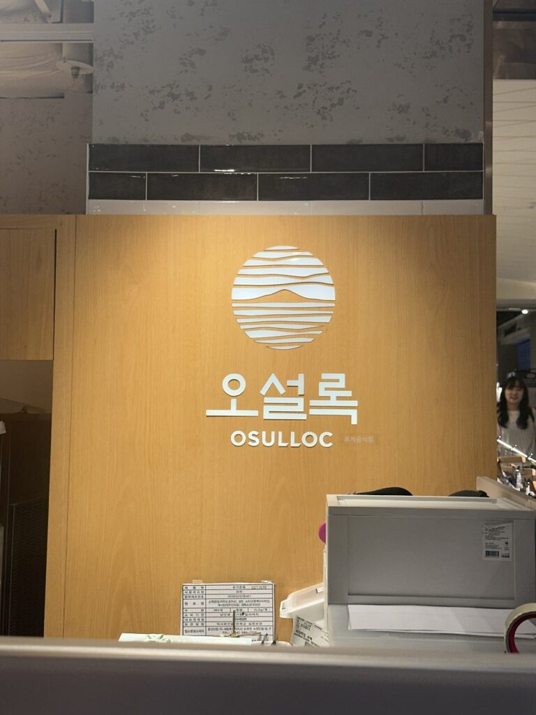 Osulloc logo on the wooden wall of the Shinsegae Yeongdeungpo store