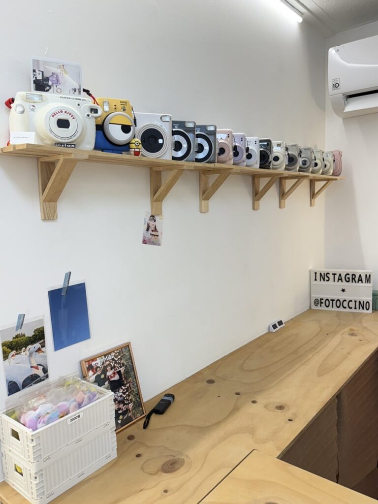 Shelf of instant cameras and an Instagram sign in the lounge