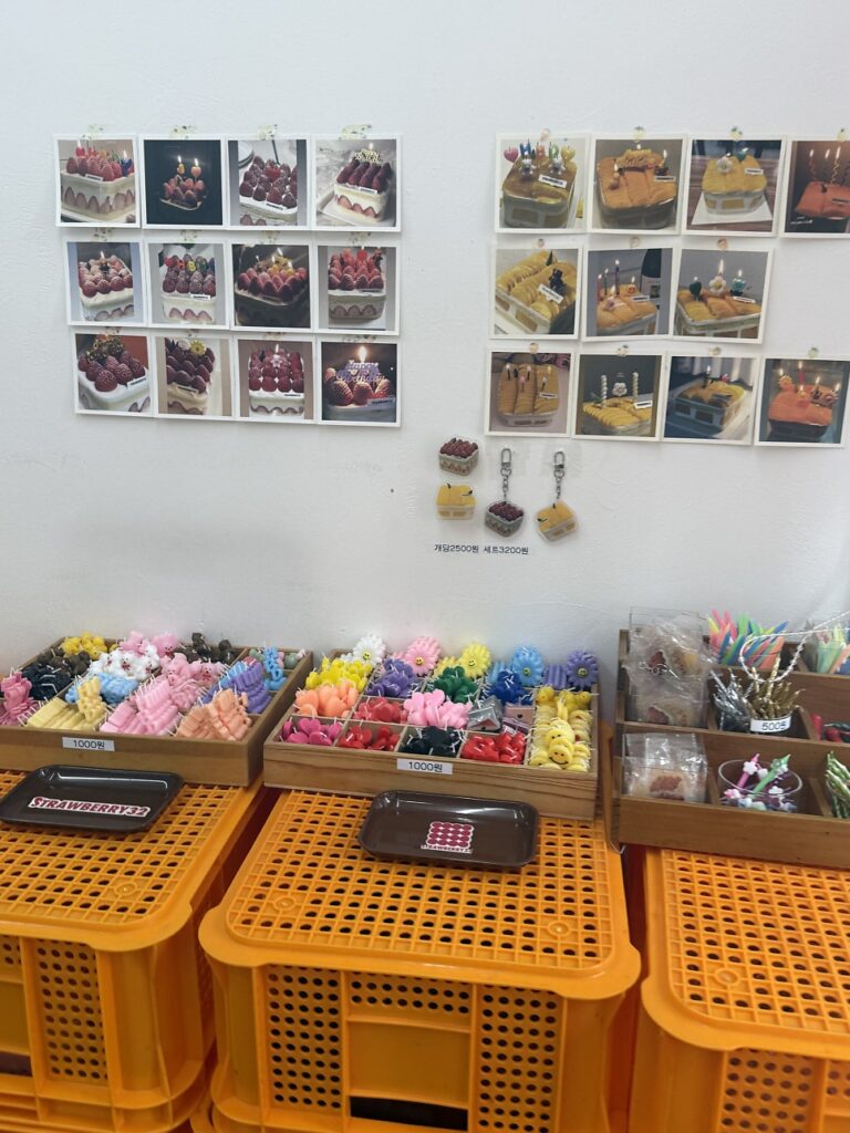 Wall of cake photos above trays of candles and party goods