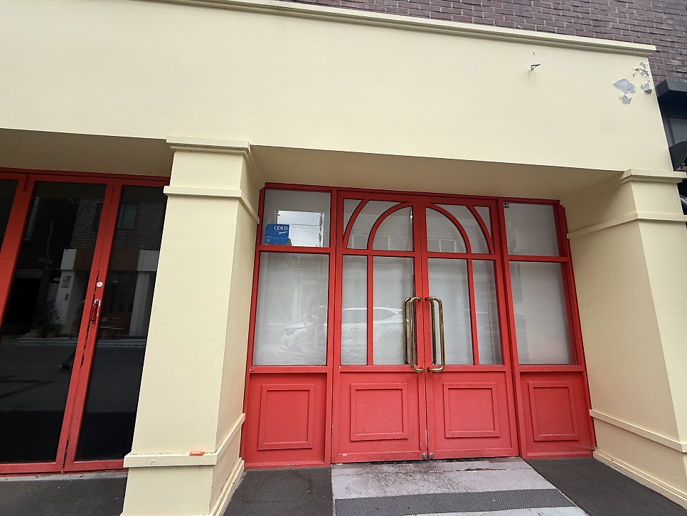 Red front door of Strawberry32 in a Yeonnam-dong alley