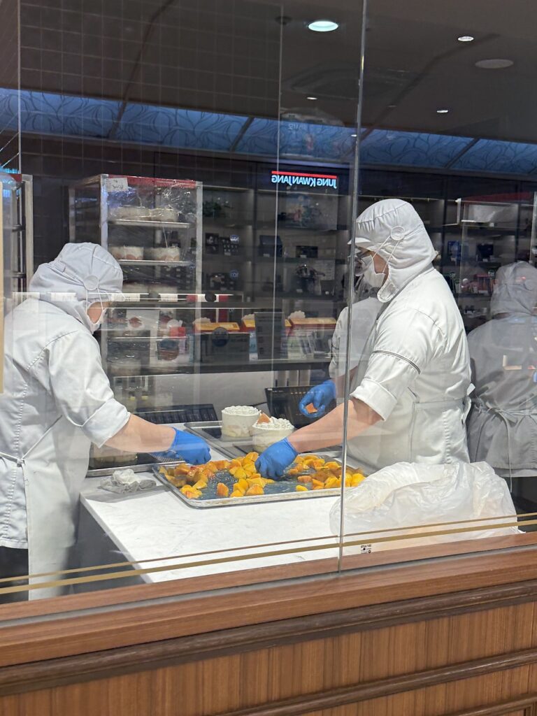 Bakers preparing peaches behind the glass