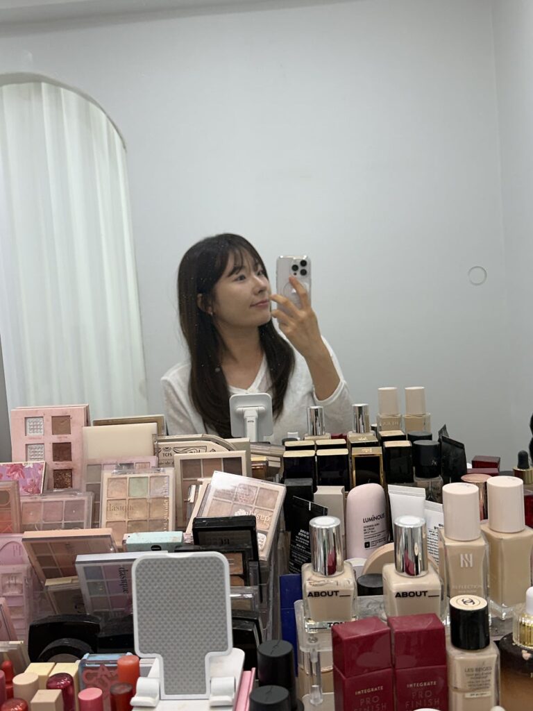 Mirror and a vanity packed with foundations and palettes