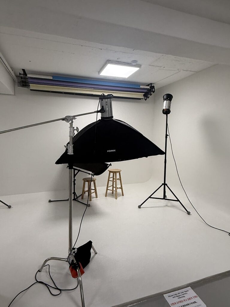 White photo studio set with lights and stools