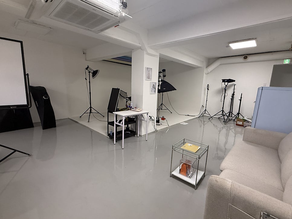 Spacious photo studio with a sofa and lighting gear
