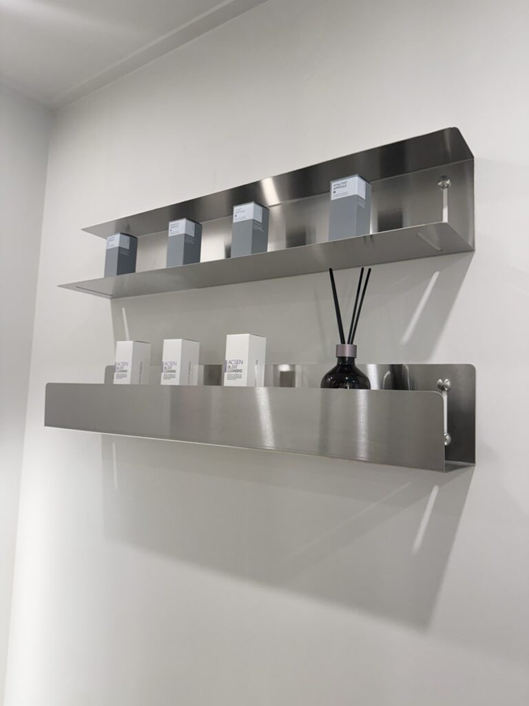 Steel shelves with skin care products and a diffuser