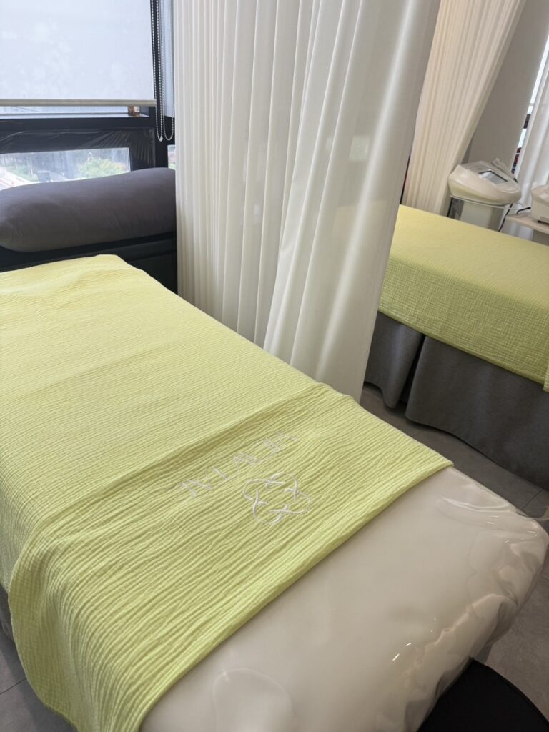 Treatment bed by the window with a soft green blanket