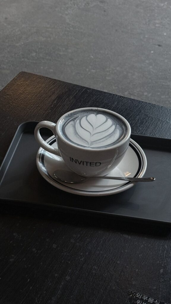 Black sesame latte with latte art in an Invited cup