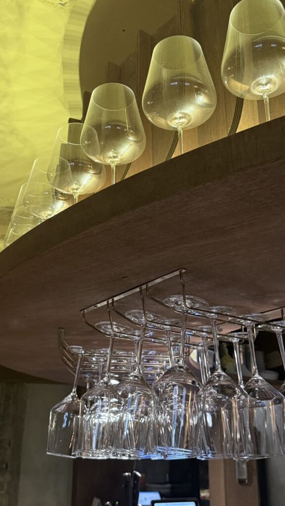 Wine glasses hanging above the bar under warm lights