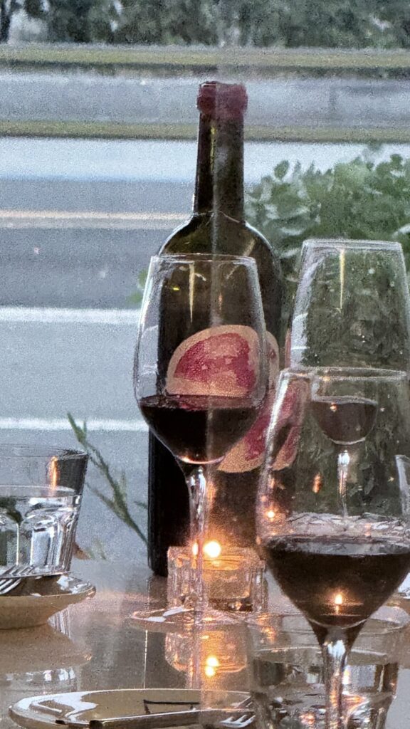 Red wine, a bottle and candles by the window at a Yongridan-gil wine bar