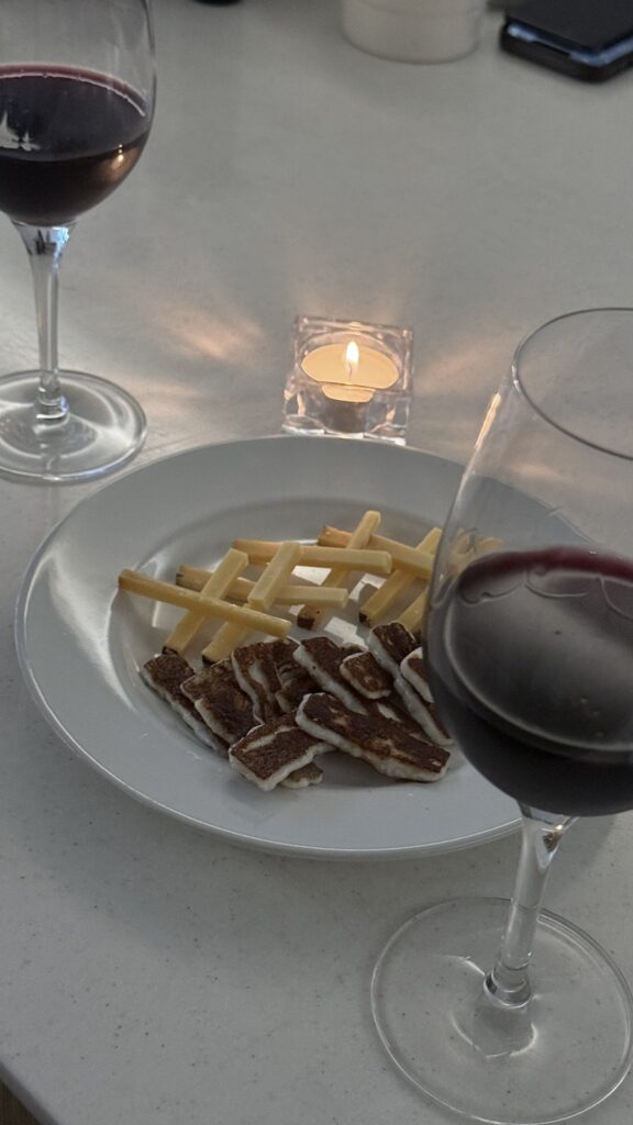 Wine and a cheese plate by candlelight